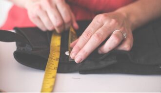 hands measuring a garment with a measuring tape